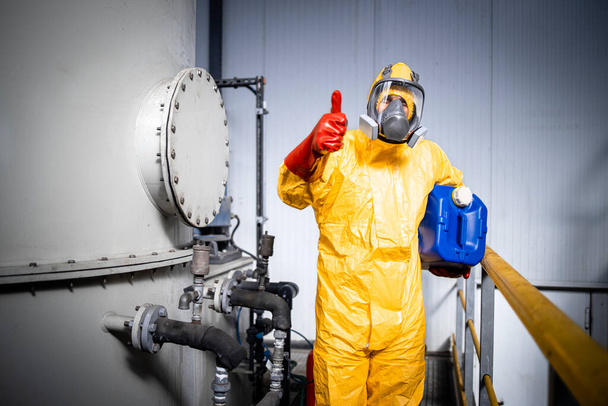 Portrait of worker in zinc galvanizing production plant holding canister with necessary chemicals and acids. - Foto, Imagen
