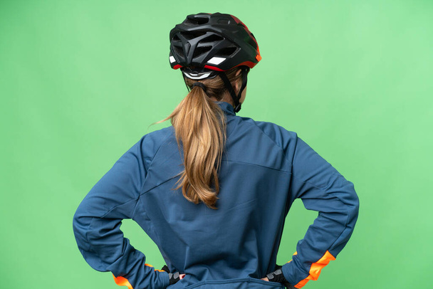 Młoda rowerzysta dziewczyna na odizolowanym tle klucza chroma w tylnej pozycji - Zdjęcie, obraz