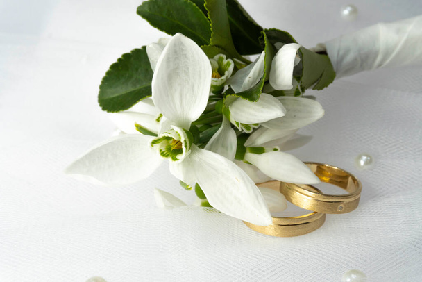 Gold Wedding rings and snowdrop flowers - Foto, Imagen