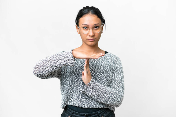 Young Uruguayan woman over isolated white background making time out gesture - 写真・画像