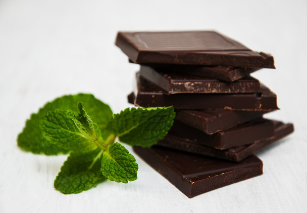 Peças de chocolate com uma folha de hortelã
 - Foto, Imagem