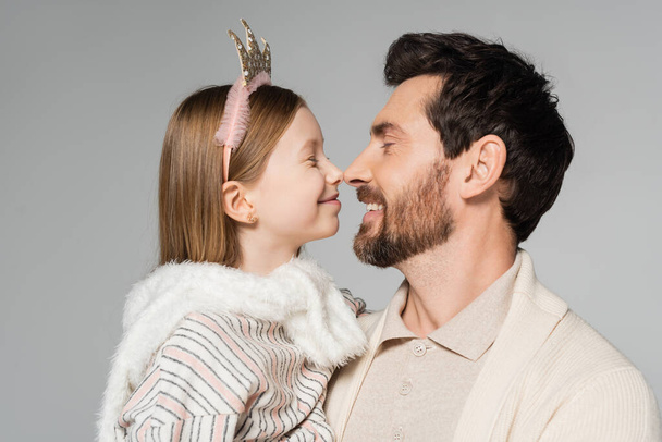 wesoły ojciec i szczęśliwa córka dotykając nosów odizolowanych na szarości  - Zdjęcie, obraz
