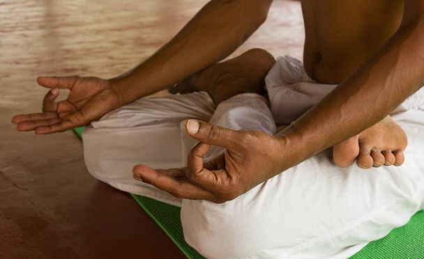 Meditationspose, Mann in Lotus-Pose auf Holzboden  - Foto, Bild