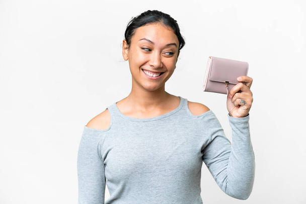 Young Uruguayan woman holding a wallet over isolated white background with happy expression - Photo, Image