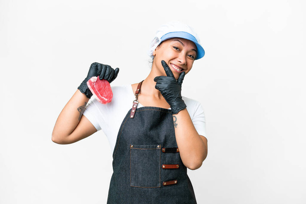Metzgerfrau trägt Schürze und serviert frisch geschnittenes Fleisch vor isoliertem weißen Hintergrund glücklich und lächelnd - Foto, Bild