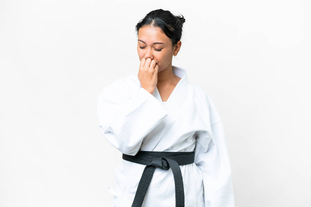 Young Uruguayan woman doing karate over isolated white background having doubts - Zdjęcie, obraz
