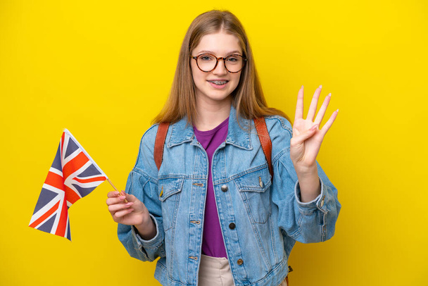 Teenager Russian girl holding an United Kingdom flag isolated on yellow background happy and counting four with fingers - Photo, Image