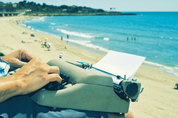 Nuori mies kirjoittaa rannalla
 - Valokuva, kuva