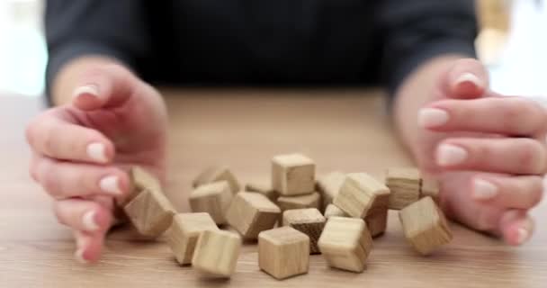 Le mani di donna lanciano cubi di legno su tavolo. Ricerca di idee creative e strategia aziendale - Filmati, video