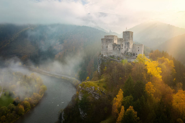 Légi felvétel a Strecno kastélyról. Középkori vár áll a magas kalcit szikla felett folyó Vah. Drámai kilátás vár ősszel hegyi táj, világít a napsugár. Emlékmű koncepció, Szlovákia. - Fotó, kép
