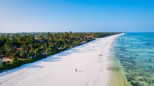 Geniet van een luxe uitje aan het Kiwengwa-strand van Zanzibar, waar het witte zand, turkoois water en palmbomen een serene en verfrissende sfeer creëren voor een onvergetelijke vakantie. - Foto, afbeelding