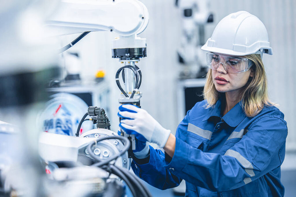 інженер жінка працівник, що працює з роботизованою рукою у виробництві лабораторних досліджень промисловості заводу
 - Фото, зображення