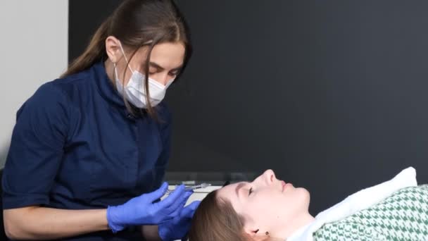 Professionelle Behandlung von Haarausfall in der Klinik. Ein Trichologe verabreicht einer Frau eine Spritze gegen Haarausfall. Moderne Kosmetologie - Filmmaterial, Video