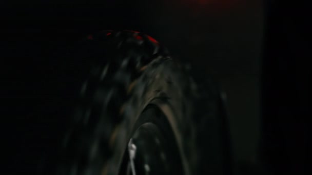 Electric dirt bike wheel starts spinning. Close-up. Rear red light. - Filmati, video