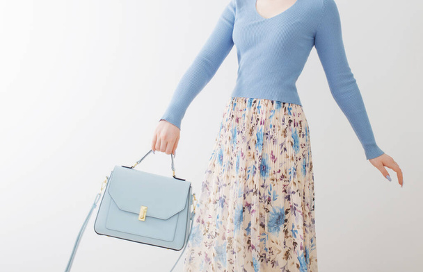 young girl in blue blouse  and pleated skirt with blue handbag on white background - Fotoğraf, Görsel