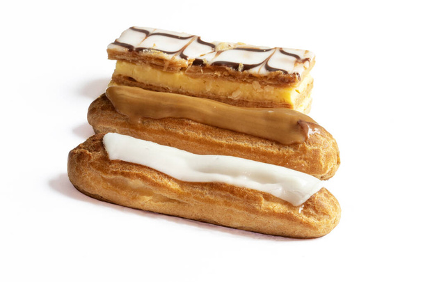Patisseries millefeuille, eclairs a la vanille et au cafe sur fond blanc - Photo, Image