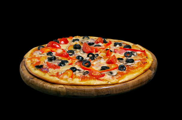 Vegetarian pizza, on a wooden kitchen board. Isolated on black background - Photo, Image