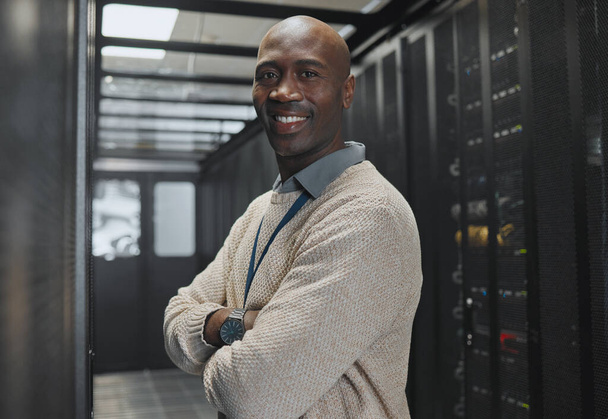 Fekete ember, IT technikus a szerverszobában és portré mosollyal, vállalati nagyszámítógép és szoftverfrissítés. Hálózat, adatközpont és kiberbiztonság. Afrikai férfi és mérnöki digitális infrastruktúrával. - Fotó, kép