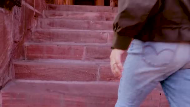 chica entrando en piedra roja arquitectura antigua templo hindú desde un ángulo único en el día - Metraje, vídeo