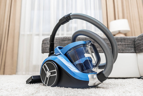 Modern vacuum cleaner in the living room. Vacuum cleaner on the background of the home interior. - Foto, Imagen