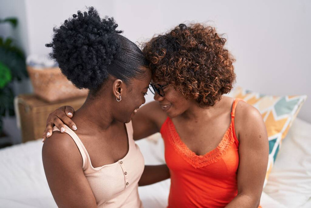 African american women mother and daughter sitting on bed at bedroom - Photo, Image