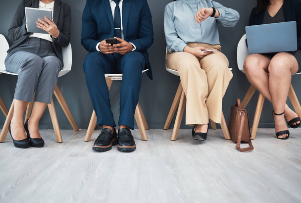 Legs, recruitment and business people in waiting room for interview with human resources. Hr hiring, job opportunity and group of candidates, men and women with devices in company for employment - Photo, Image