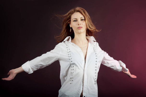 Woman opened her arms in white shirt, happy, fashion model. Shoot in studio - Photo, Image