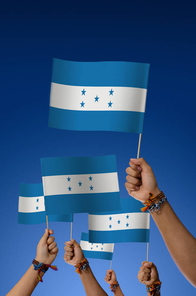 Group of young people holding Honduras flags on blue background - Valokuva, kuva