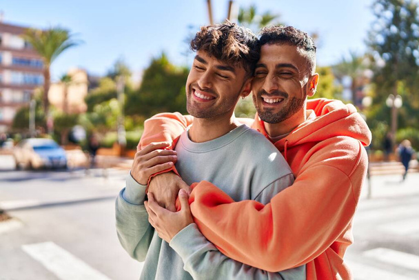 Two man couple hugging each other standing at street - Photo, image