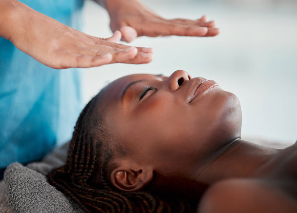 Чорна жінка, масаж Рейкі та розкішне курортне лікування молодої жінки, готова до масажу обличчя салону. Догляд за шкірою, краса і оздоровча клініка з клієнтом відчуває спокій і зеніт від досвіду цілісної терапії
. - Фото, зображення