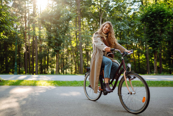 Beautiful woman  riding bicycle in  park. Lifestyle. Relax, nature concept. Spring time. - Fotó, kép