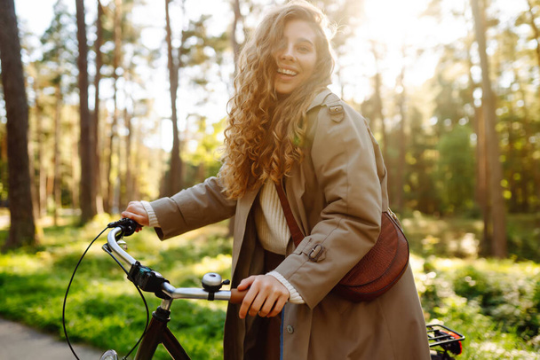 Beautiful woman  riding bicycle in  park. Lifestyle. Relax, nature concept. Spring time. - 写真・画像
