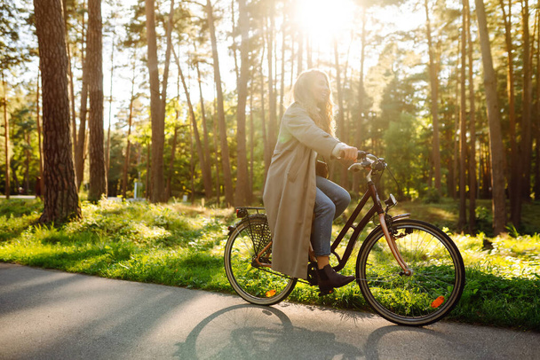 Beautiful woman  riding bicycle in  park. Lifestyle. Relax, nature concept. Spring time. - Foto, Bild