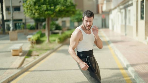 Hombre hispano joven karate entrenamiento de combate en el parque - Foto, imagen
