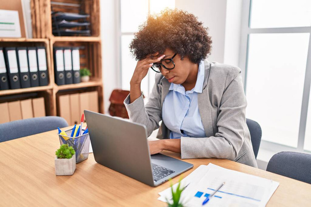 Trabajadora de negocios afroamericana estresada usando laptop en oficina - Foto, Imagen