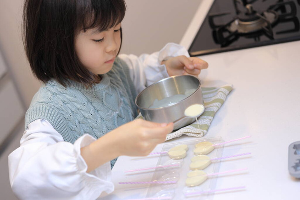 Japanilainen opiskelija tyttö ruoanlaitto valkoinen suklaa (8 vuotta vanha) - Valokuva, kuva