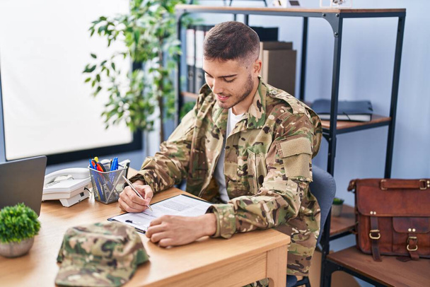 Giovane uomo ispanico soldato dell'esercito firma contratto in ufficio - Foto, immagini
