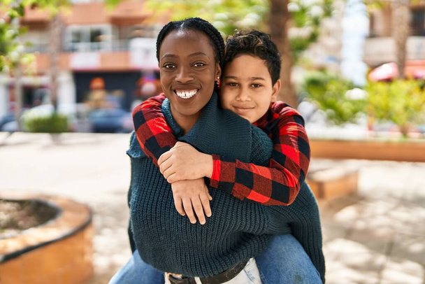 Afrikai amerikai anya és fia mosolyogva magabiztosan ölelgetik egymást a parkban - Fotó, kép