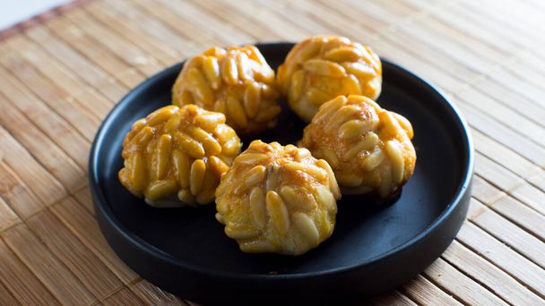 Penellets. Small sweets of various shapes, made from almond and potato dough, and covered with almonds or pine nuts. - Foto, Imagen