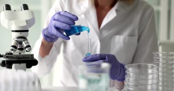Επιστήμονας ρίχνει μπλε υγρό τζελ στο δοκιμαστικό σωλήνα. Χημικά πειράματα και εργαστηριακή έρευνα - Πλάνα, βίντεο