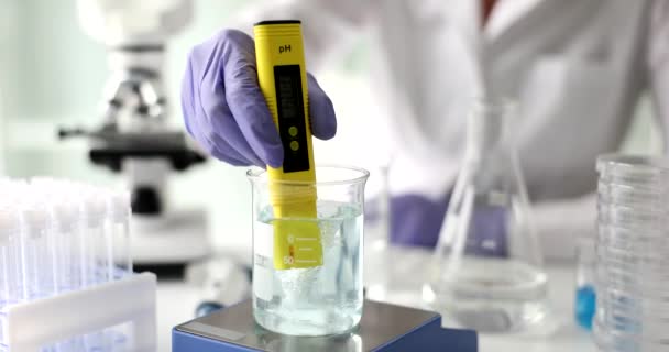 Científico utiliza solución química y prueba de laboratorio de calidad del agua o medidor de pH en el laboratorio. Investigación sobre calidad del agua - Metraje, vídeo