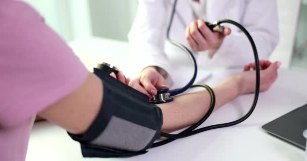 Lääkäri tarkistaa verenpainemittarin avulla potilaan verenpaineen ja pulssin. Kardiologi tutkii ja hoitaa terveydenhuollon käsitettä - Materiaali, video