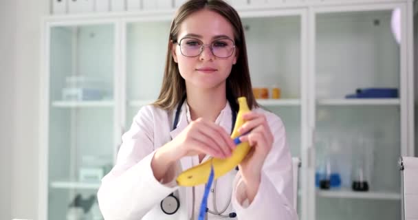 Médico urólogo cirujano sostiene plátano y cinta métrica en las manos. Disfunción eréctil y erección débil - Metraje, vídeo