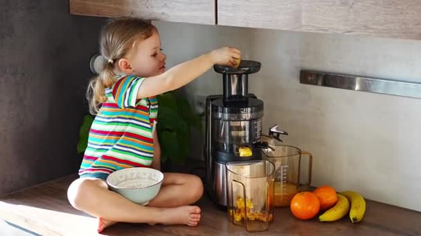 Kleines Mädchen macht frischen Saft auf dem Tisch in der heimischen Küche. Hochwertiges 4k Filmmaterial - Filmmaterial, Video