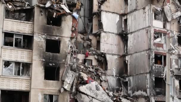 Zerstört durch einen Einschlag russischer Raketen mehrstöckiges Wohnhaus in einer ukrainischen Stadt. Eingestürzte Platten, Wände und Balkone sind zu sehen. Russland bombardiert friedliche Städte und zerstört Häuser - Filmmaterial, Video
