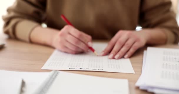 El estudiante sostiene el lápiz rojo y escribe su respuesta elegida. Estudiante o gerente de pruebas de un examen - Imágenes, Vídeo