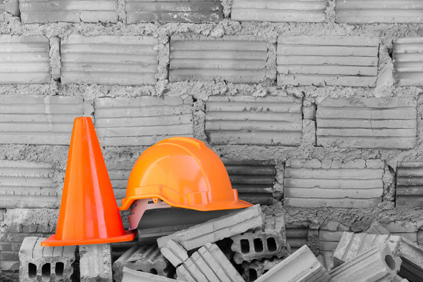 Будівельний шолом безпека і конус на будівельному майданчику
 - Фото, зображення