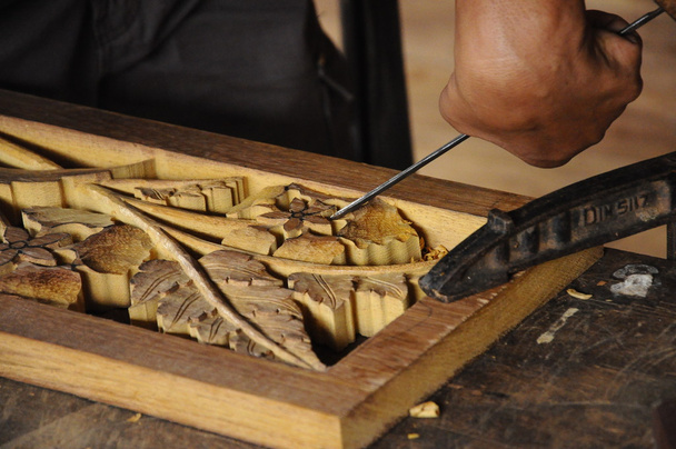 Uzdolnionym rzemieślnikiem robi drewno rzeźba metodą tradycyjną - Zdjęcie, obraz