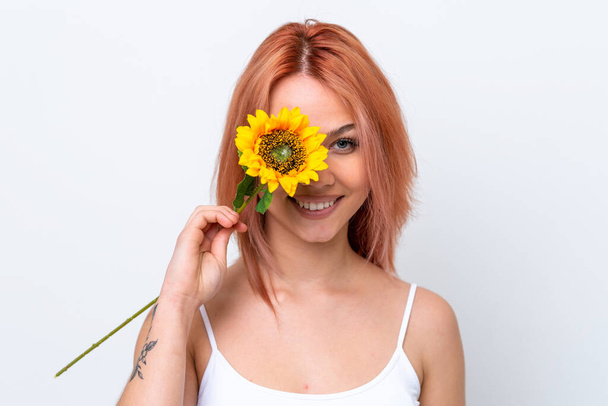 Young Russian girl isolated on white background holding a sunflower while smiling. Close up portrait - Photo, Image