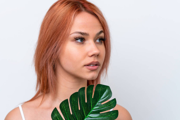 Young Russian girl isolated on white background holding a palm leaf. Close up portrait - Photo, image